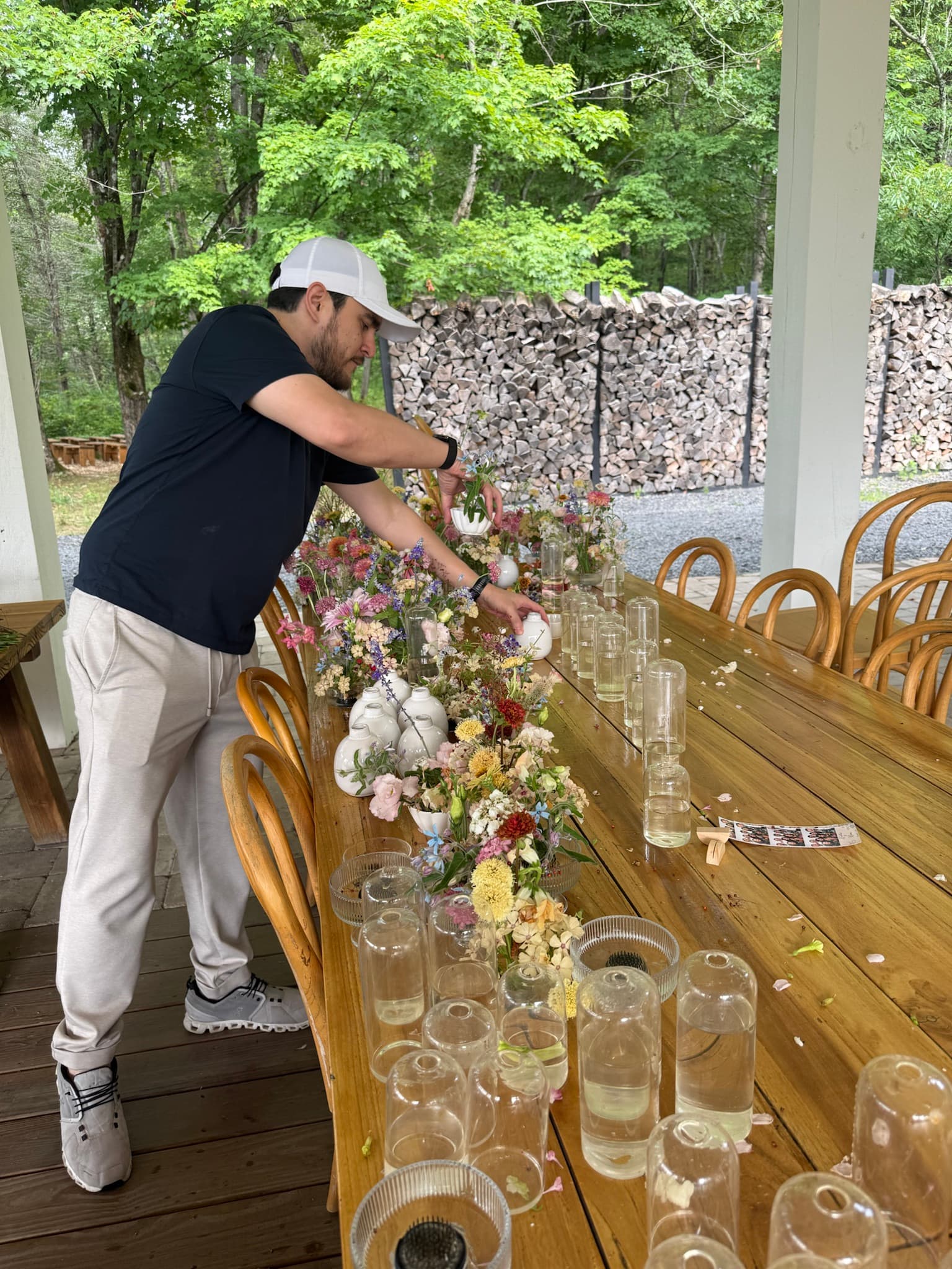 Crew member removing bud vases and flowers from a reception table